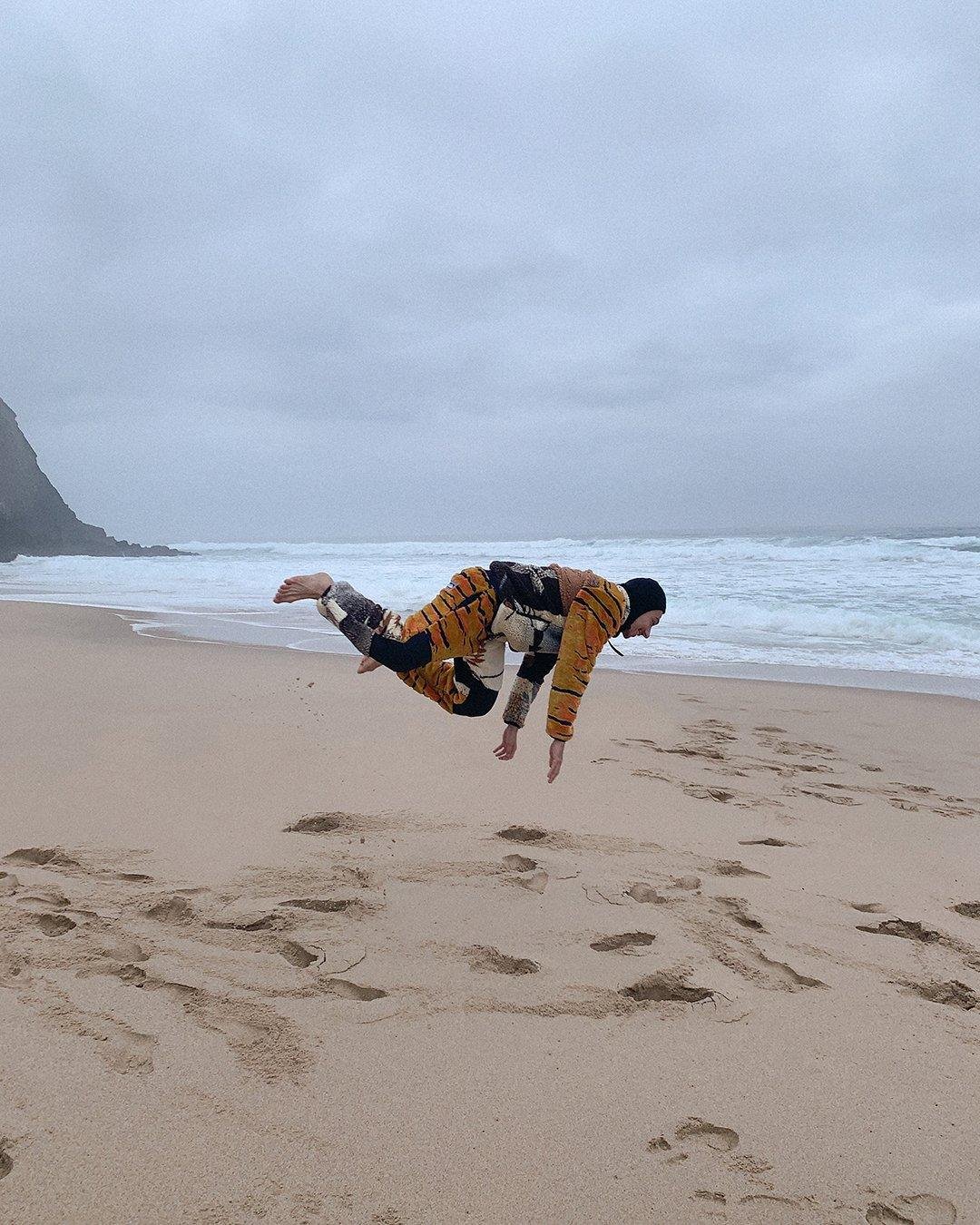 Man jumping over the sand for Visual Installment 8 in Praia Grande