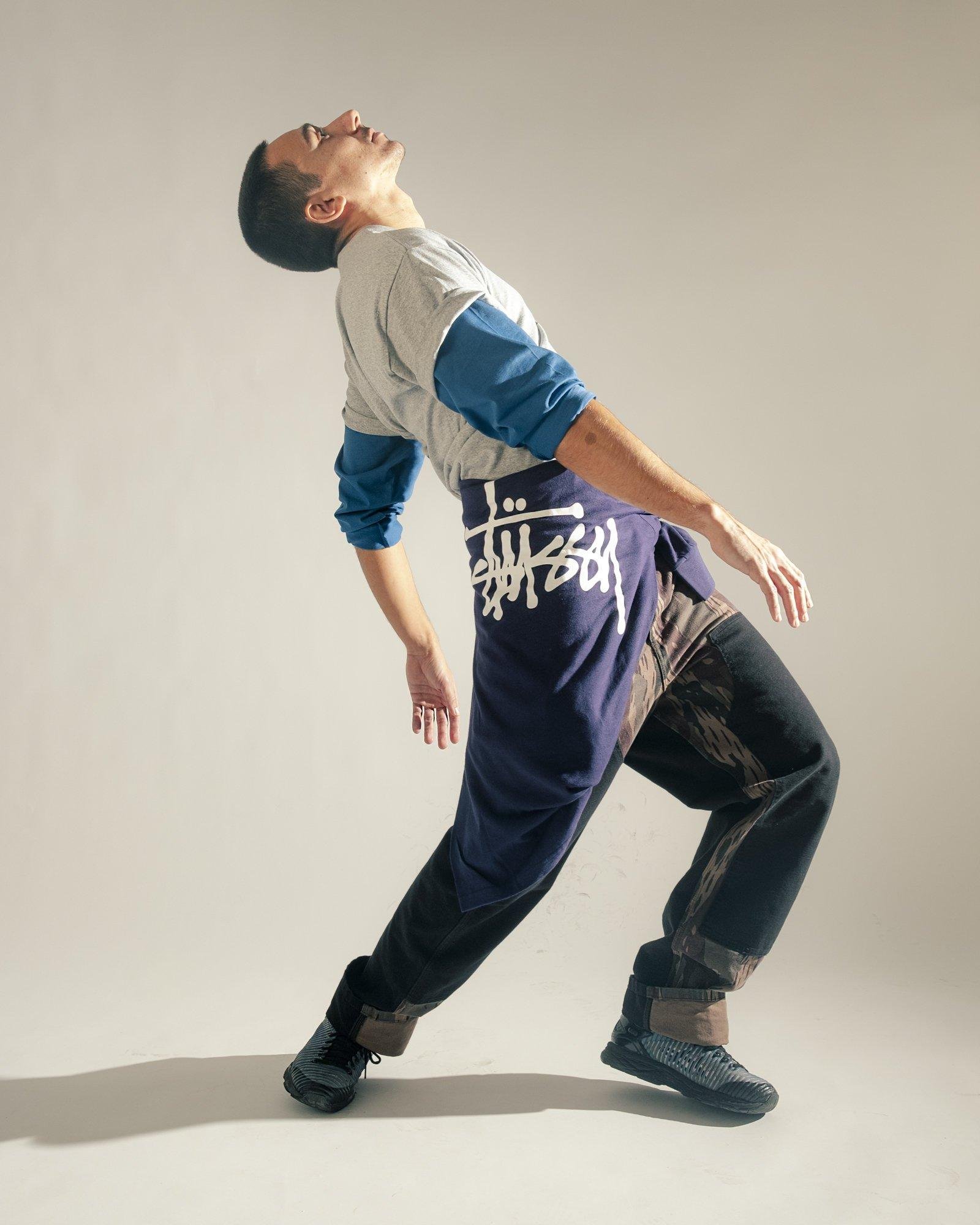 Men posing with a Stussy sweater on his waist for the Visual Installment 9.