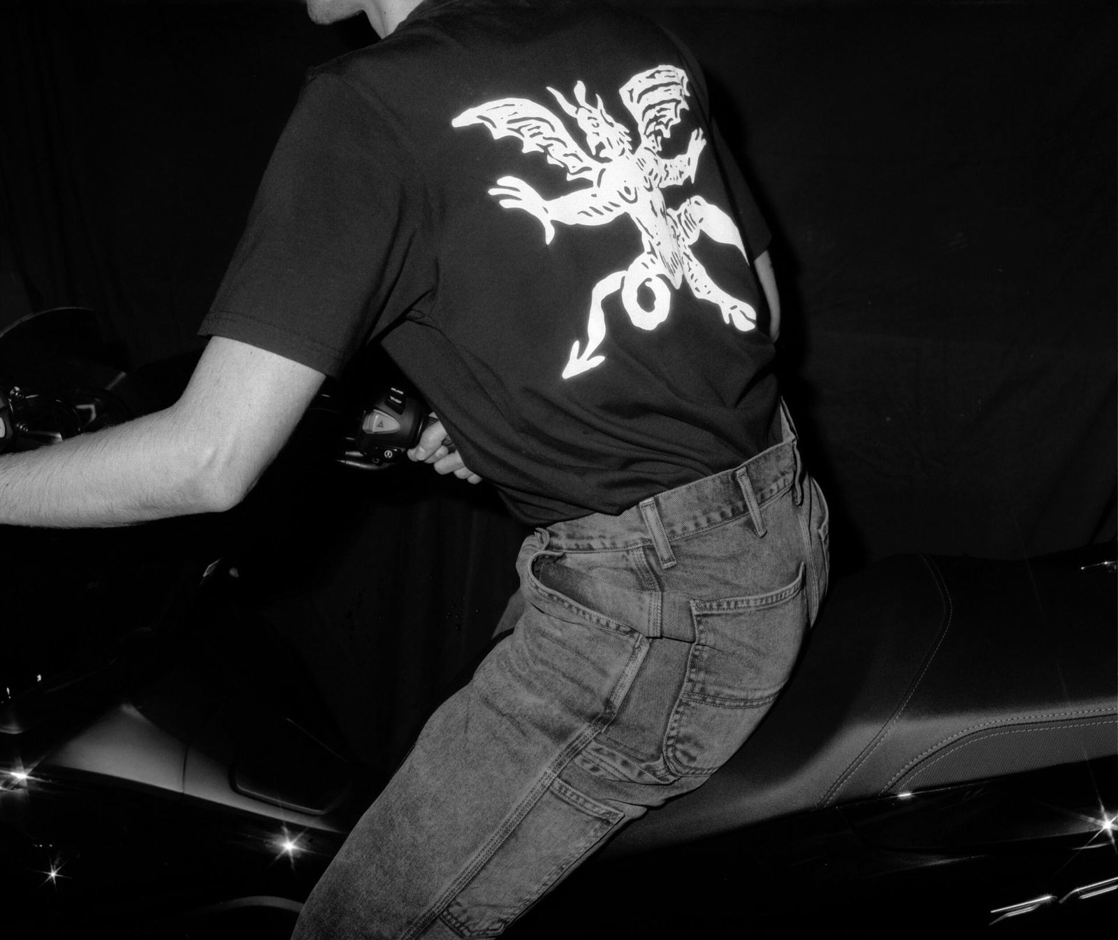 Man on a motorcycle wearing a Heresy t-shirt.