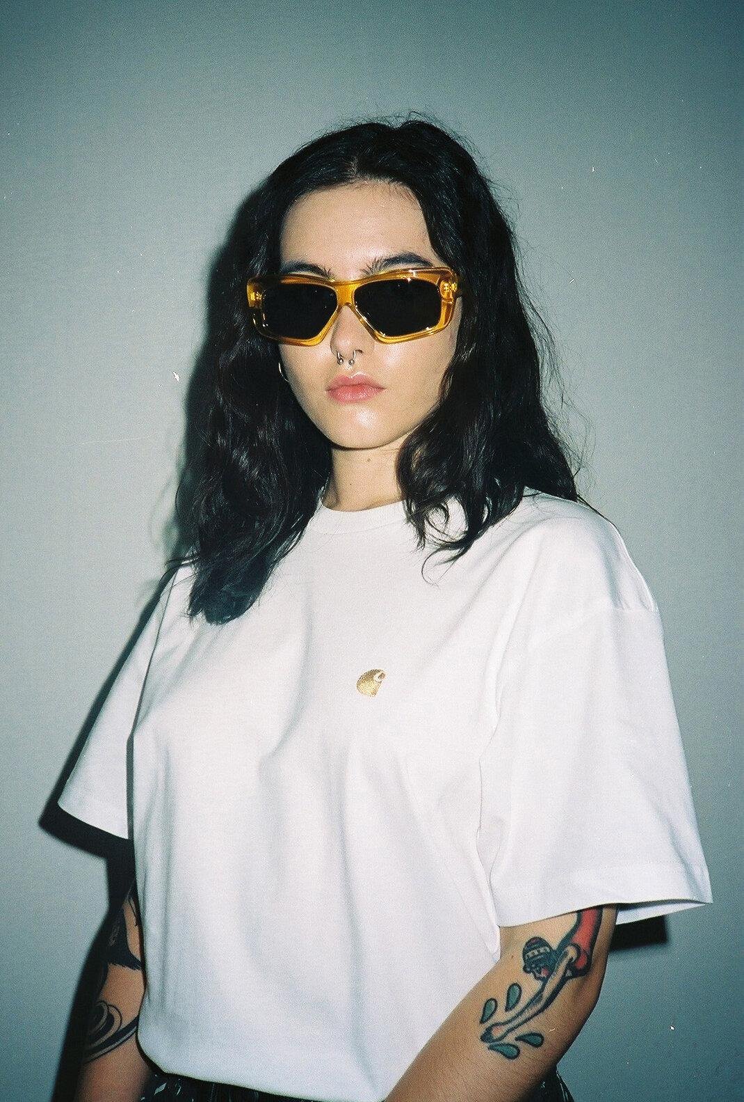 Model posing with sunglasses and a white t-shirt for Visual Instalment 2.