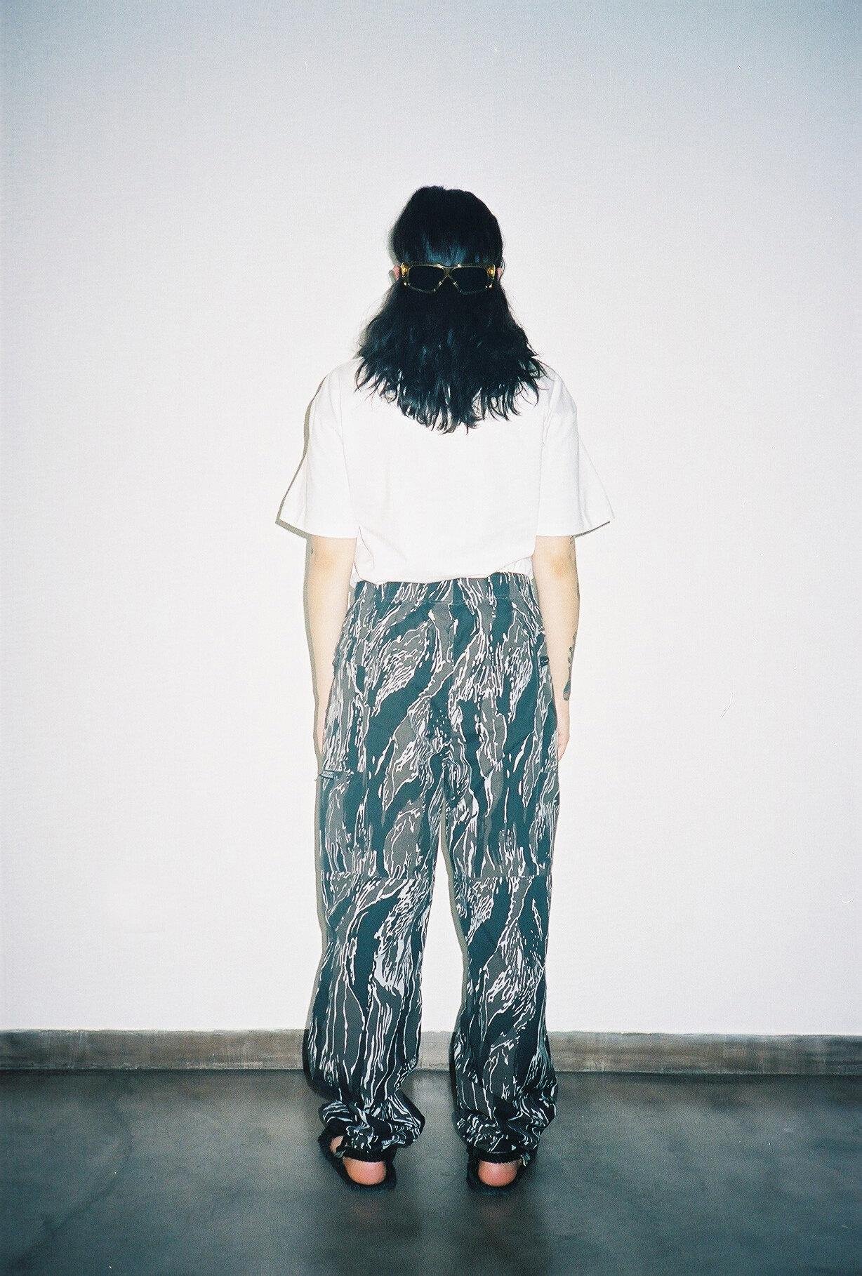 A person from behind using a white t-shirt and print pants.
