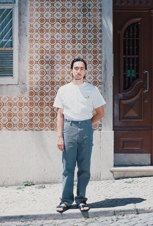 A person posing with a white t-shirt and jeans for Visual Installment 2.