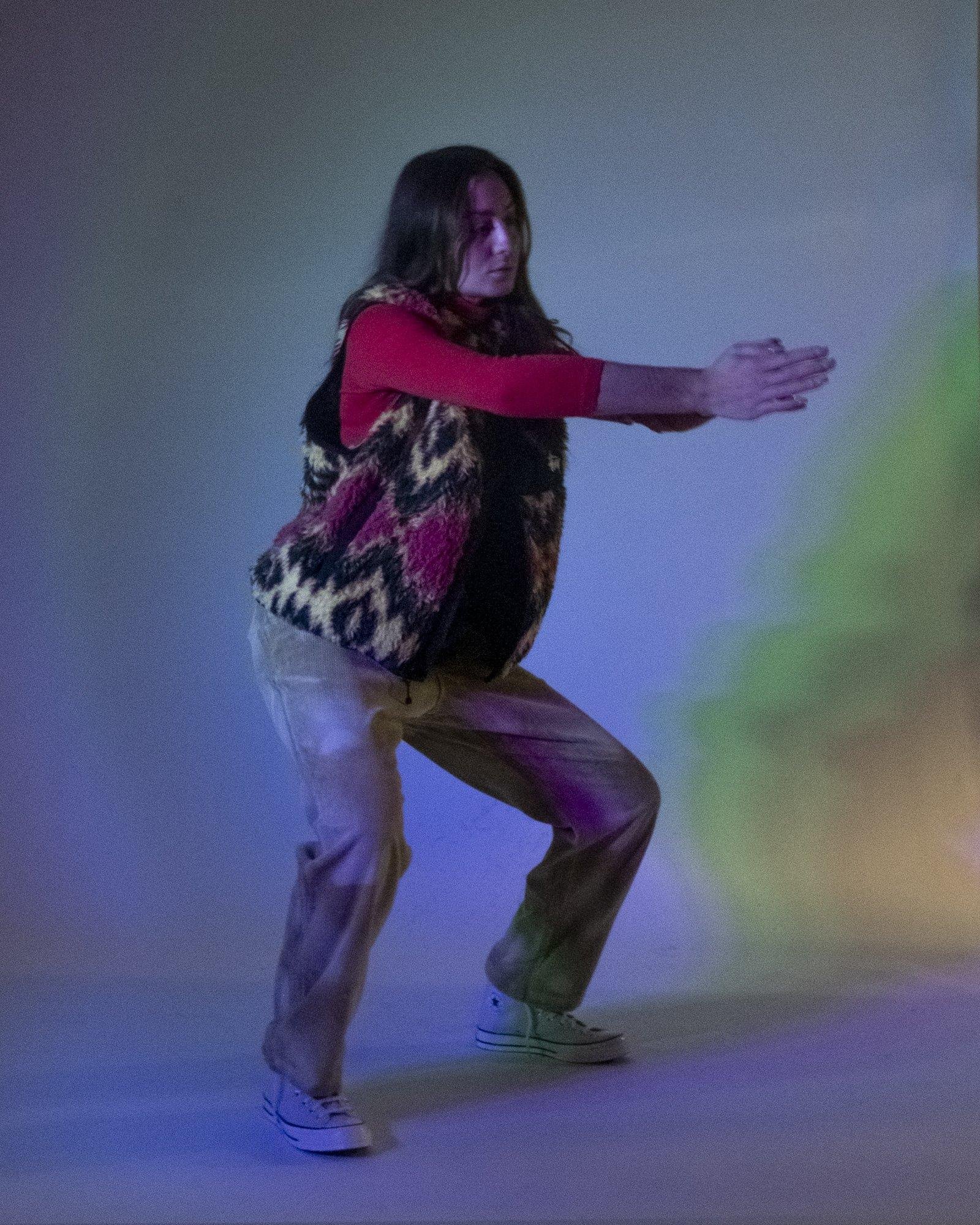 Model posing for Visual Instalment 9 in green and blue lighting.