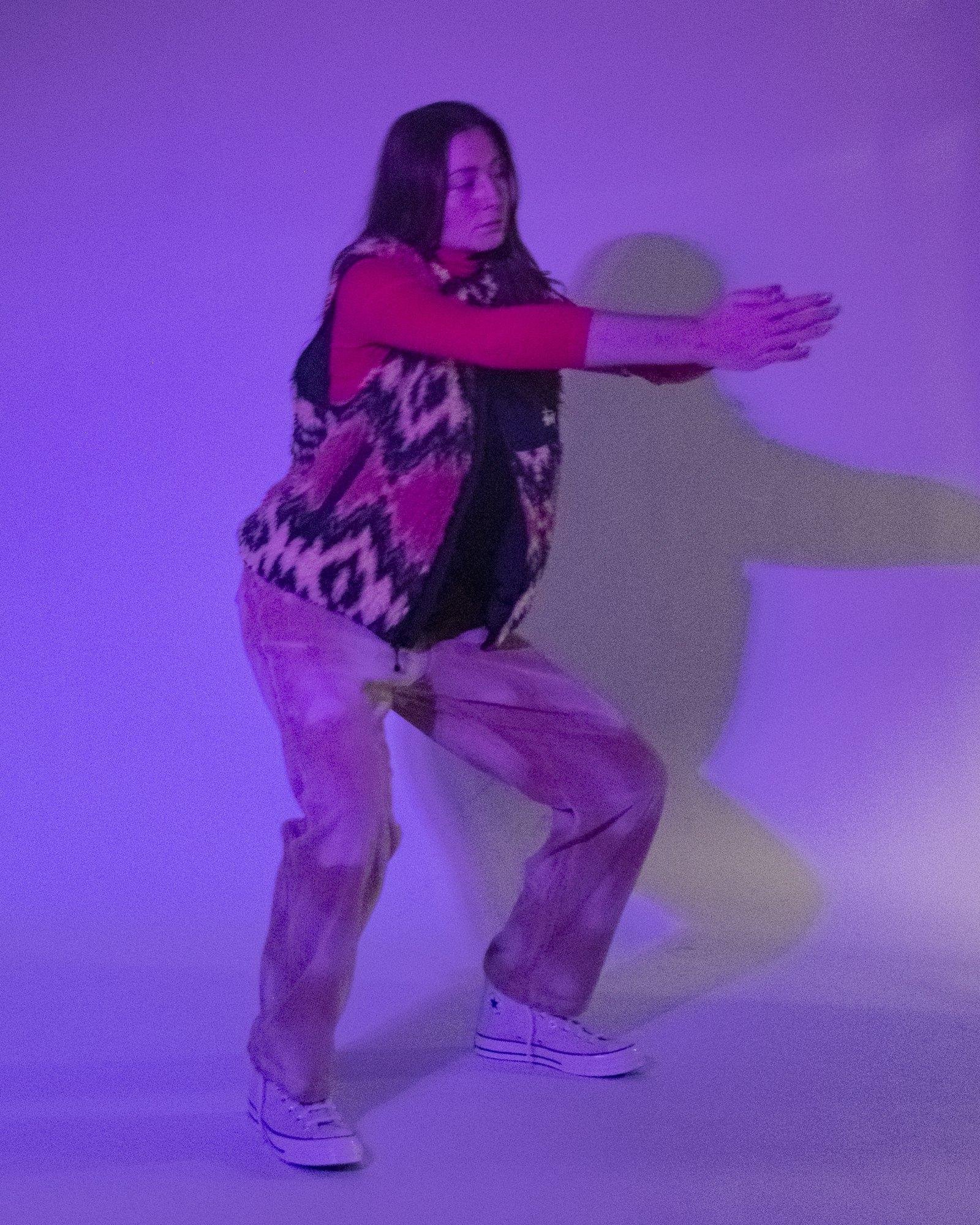 Model posing for Visual Instalment 9 in blue and violet lighting.