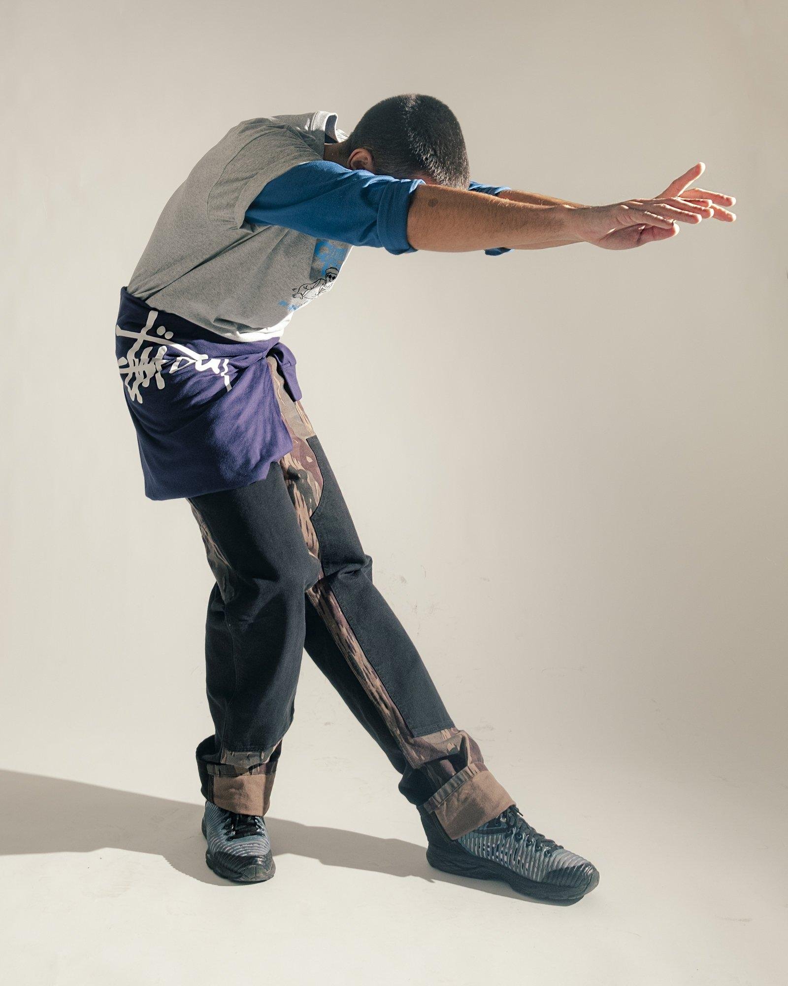 Men posing with a Stussy sweater on his waist for the Visual Installment 9.