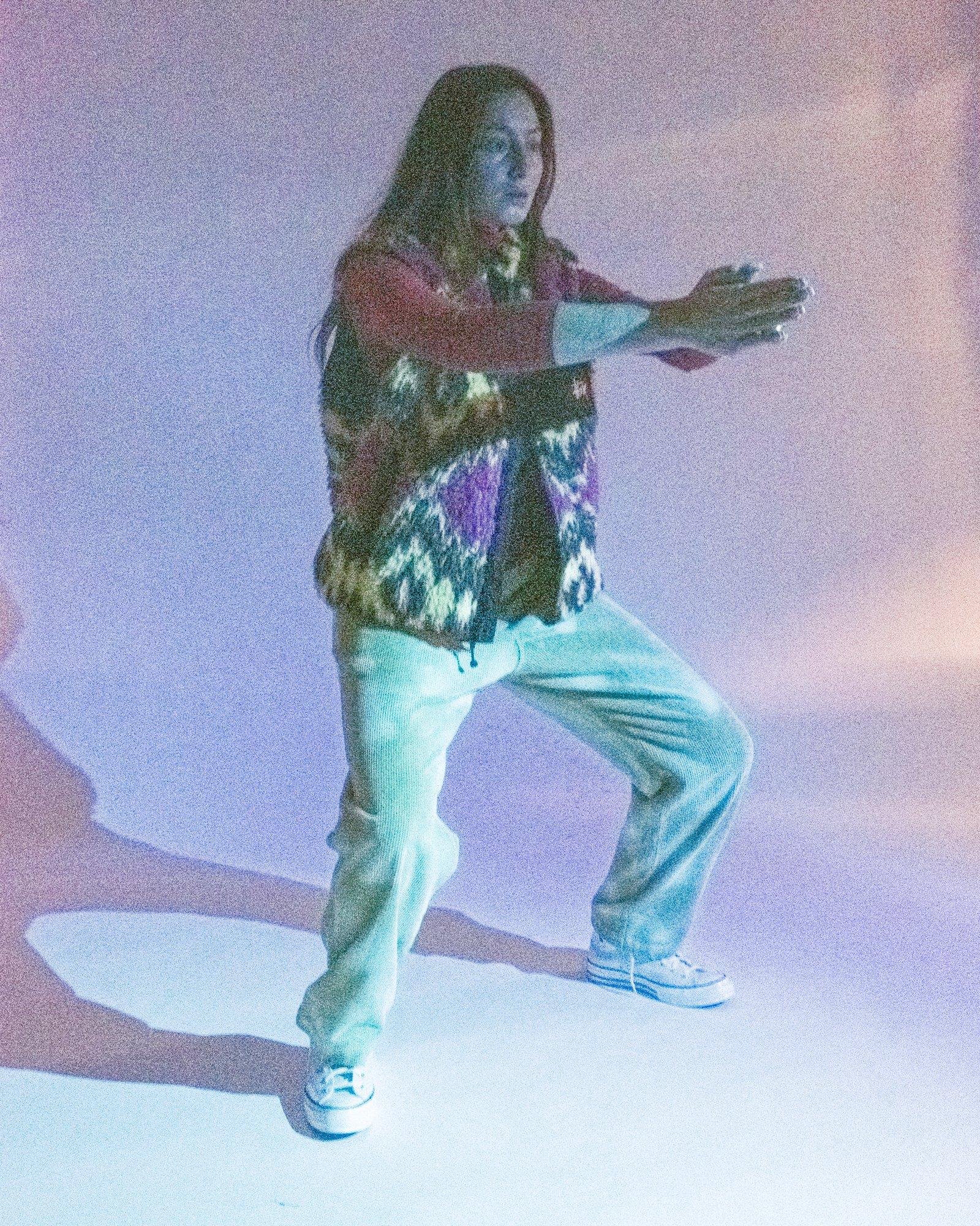 Model posing for Visual Instalment 9 in light blue lighting.
