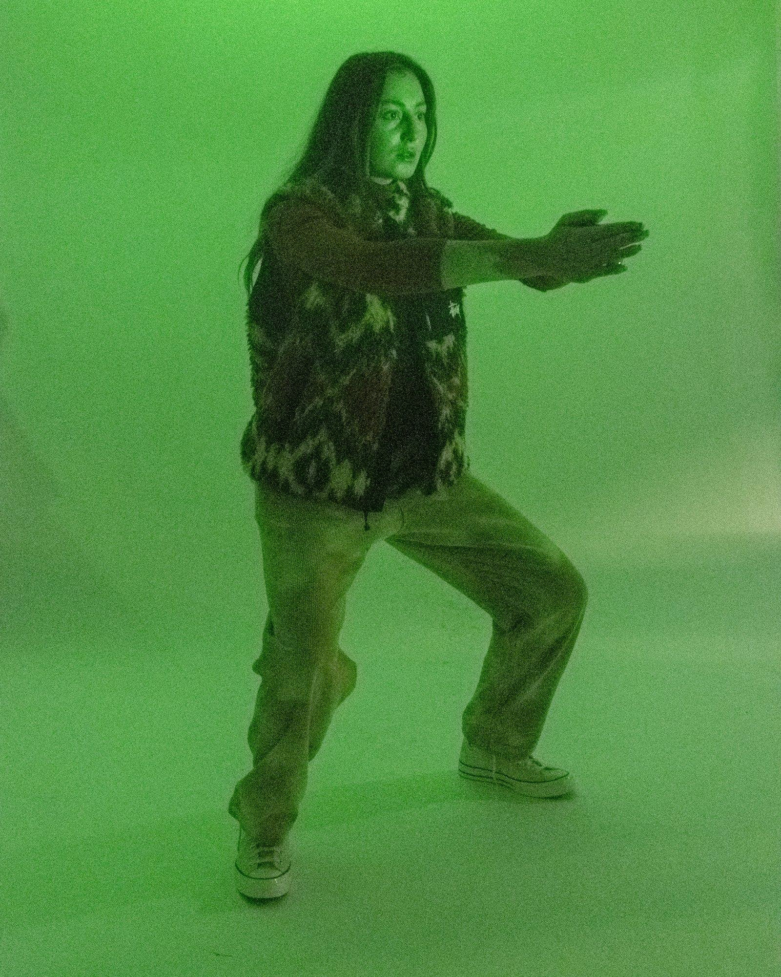 Model posing for Visual Instalment 9 in green lighting.