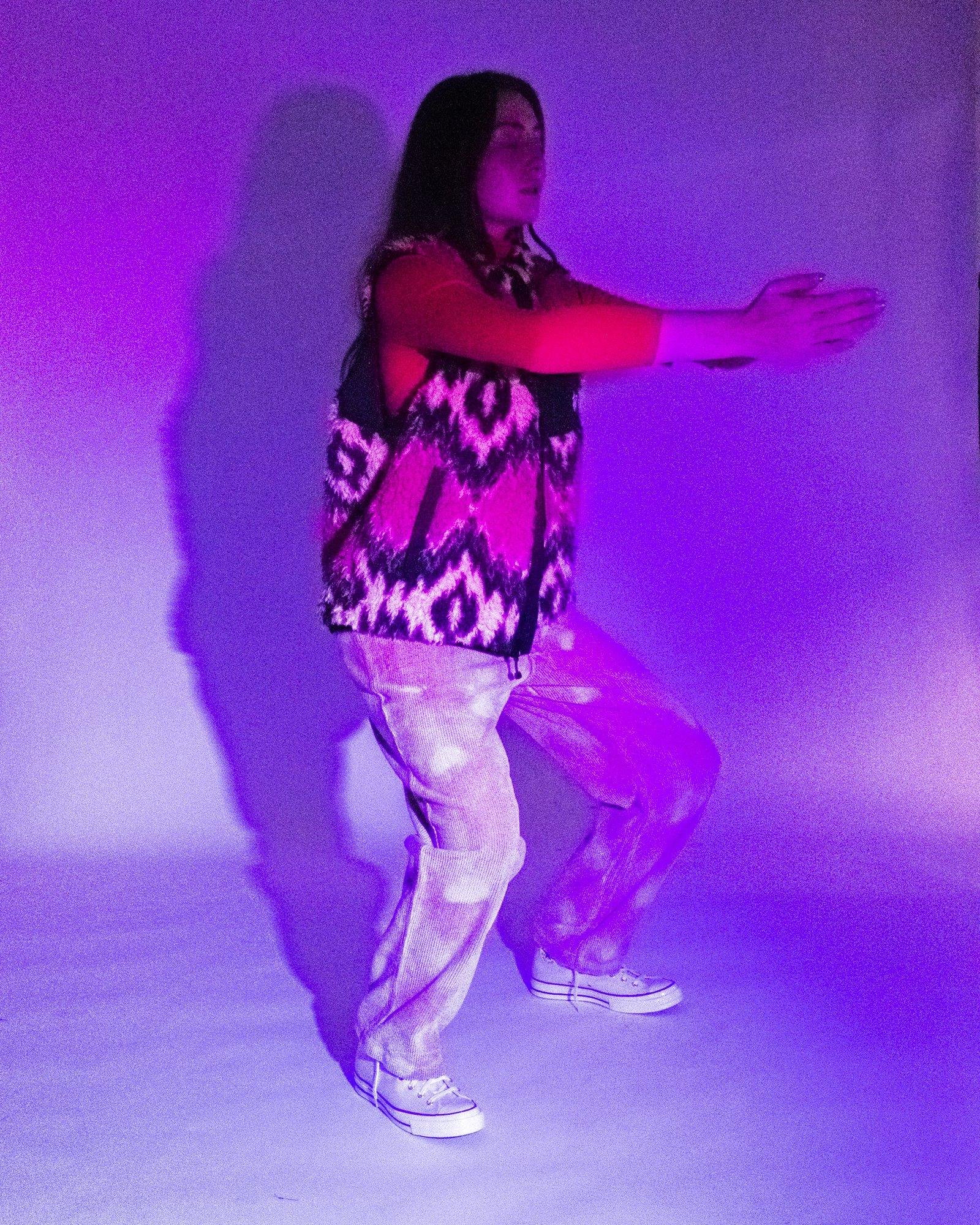 Model posing for Visual Instalment 9 in blue and red lighting.
