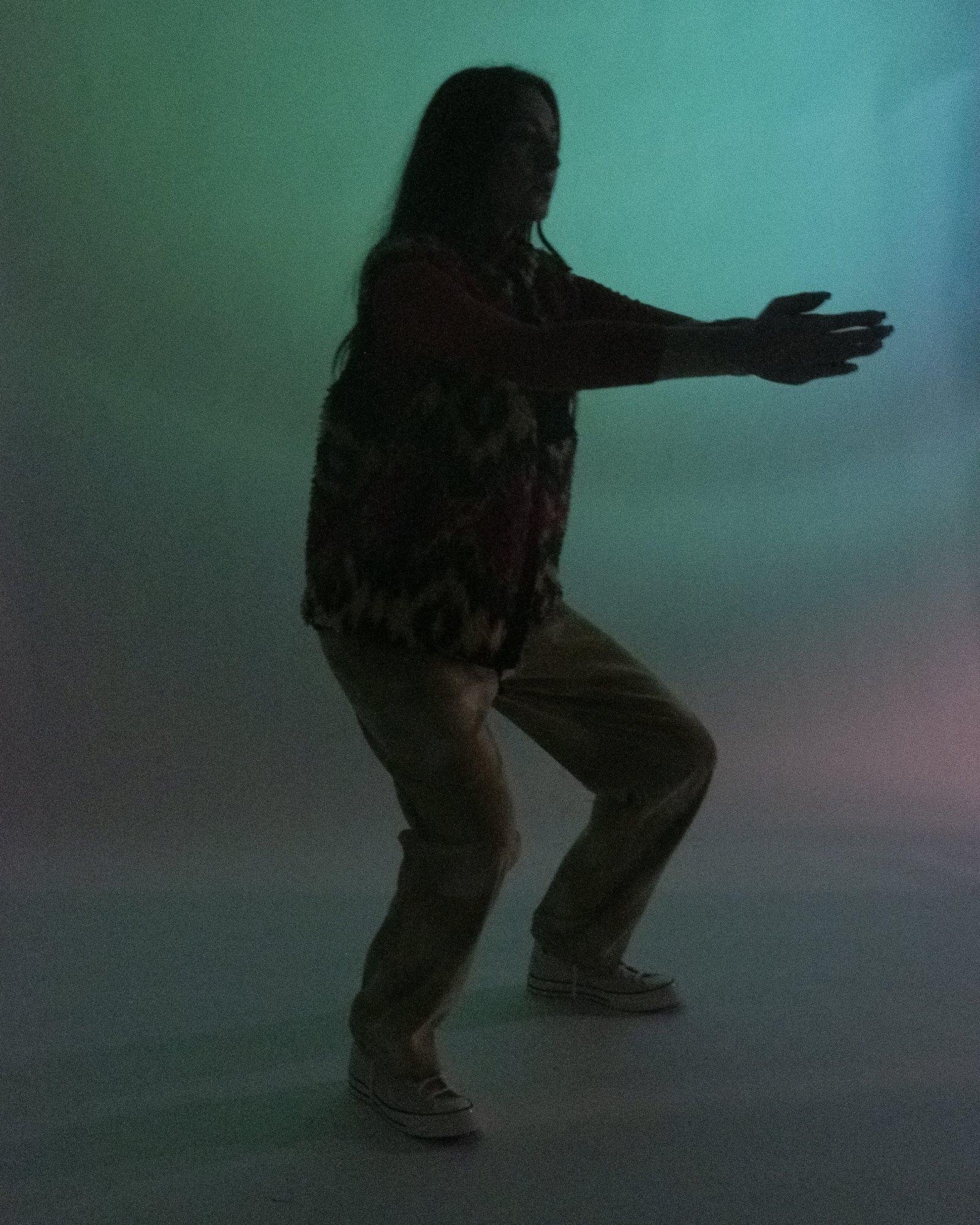 Model posing for Visual Instalment 9 in dark lighting.