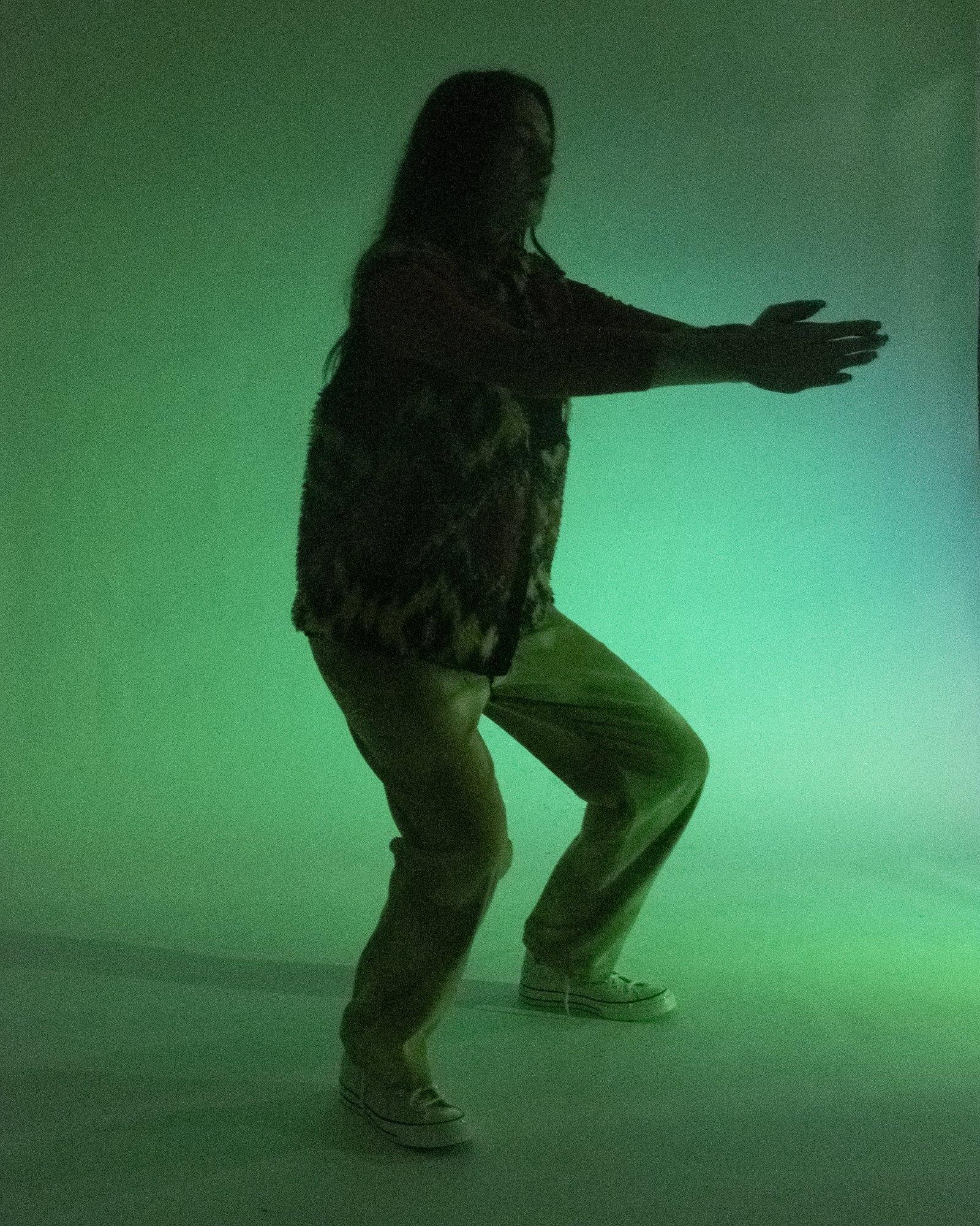 Model posing for Visual Instalment 9 in green lighting.