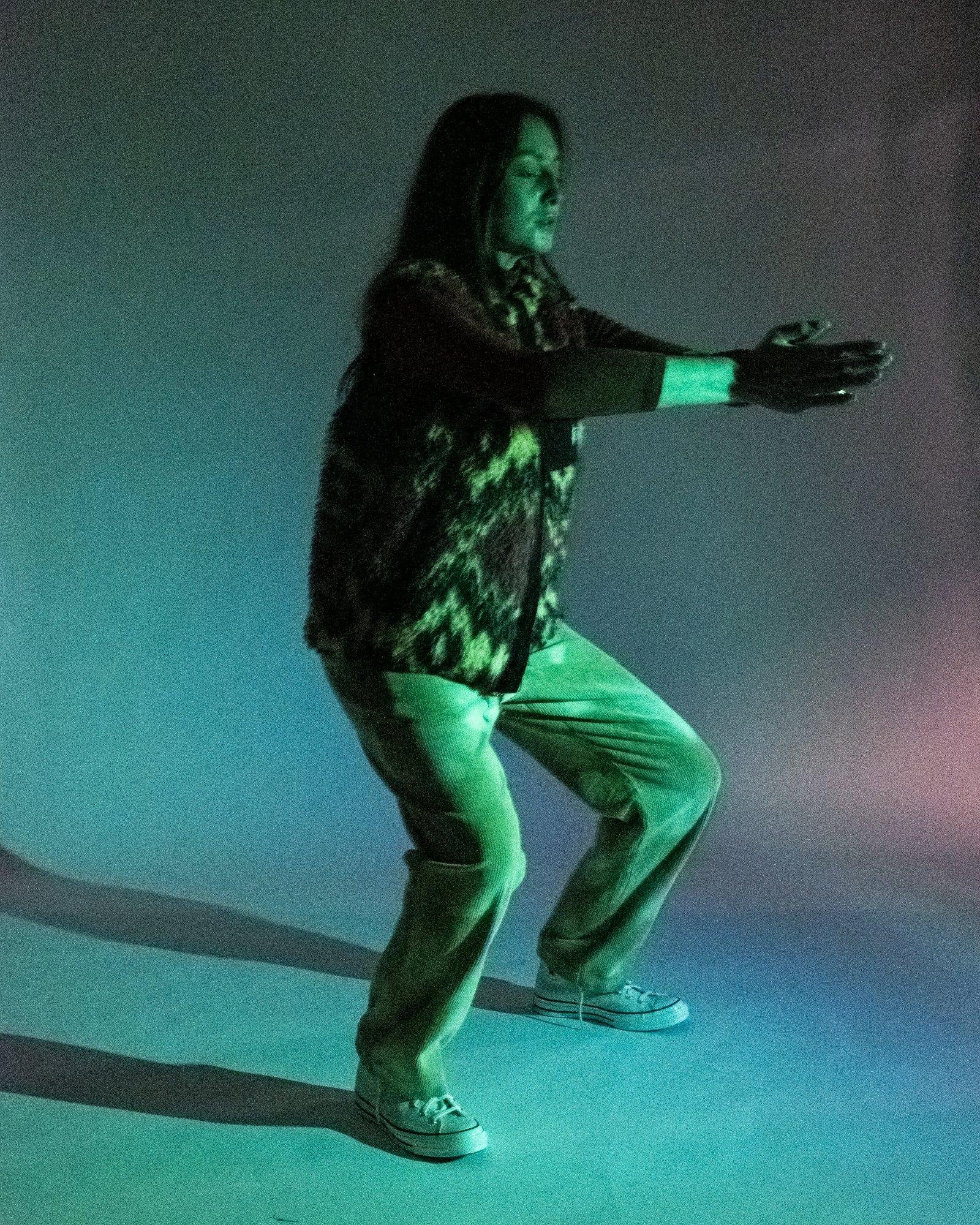 Model posing for Visual Instalment 9 in blue lighting.