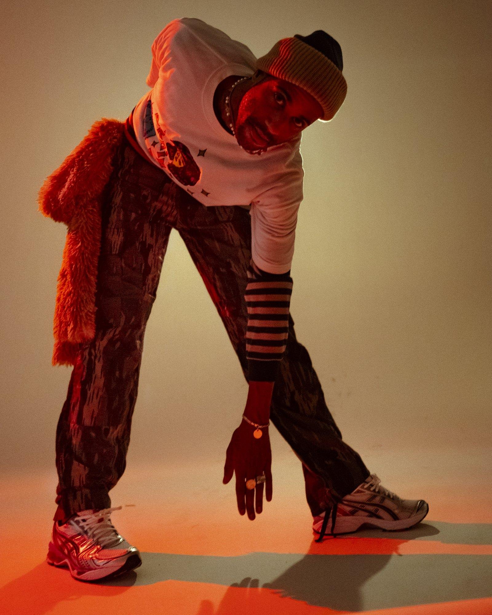 MAle Model posing for Visual Instalment 9 in yellow and orange lighting.