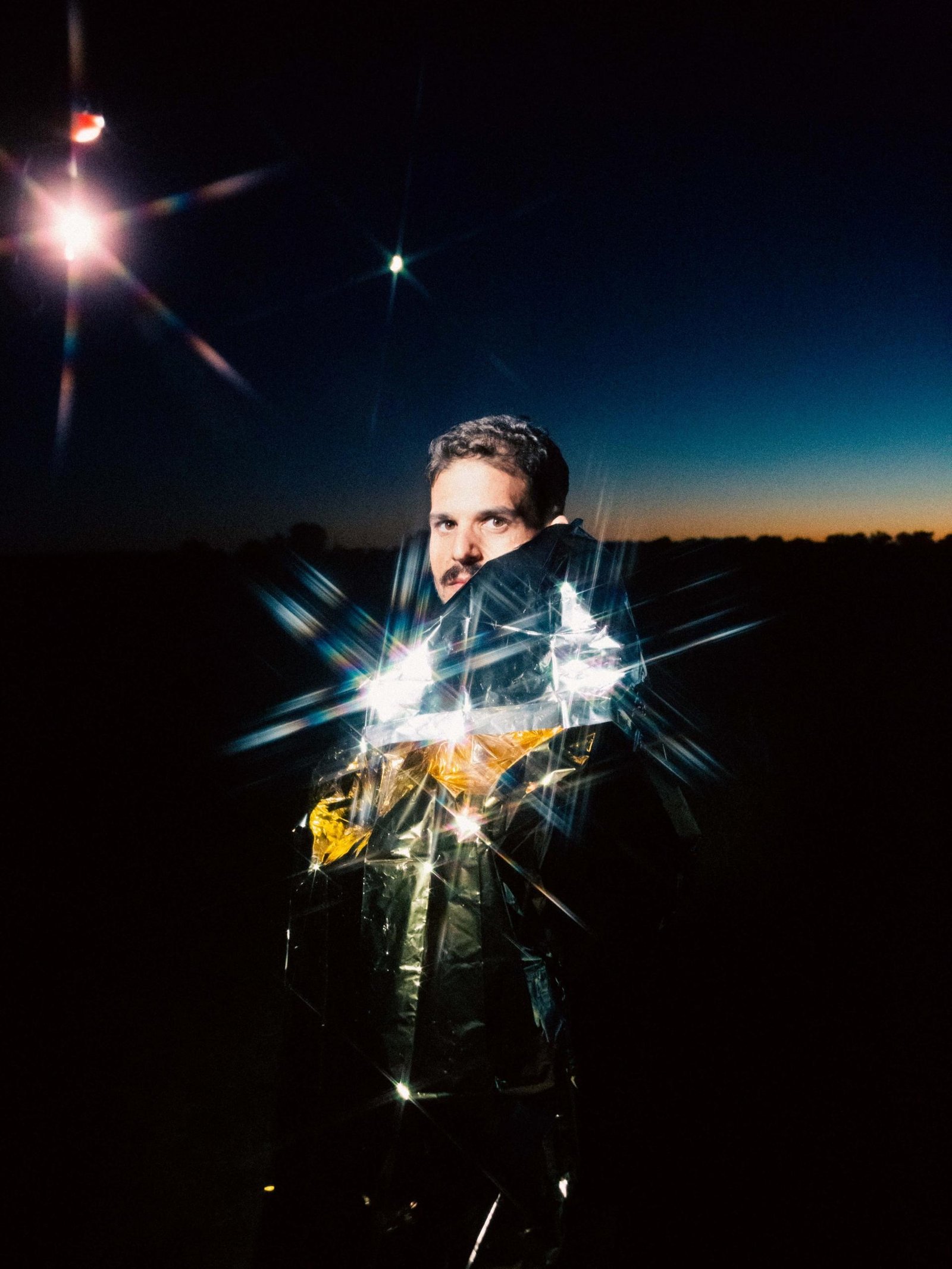 One of the photos from the Visual Installment #12, showing a man with a shiny blanket.