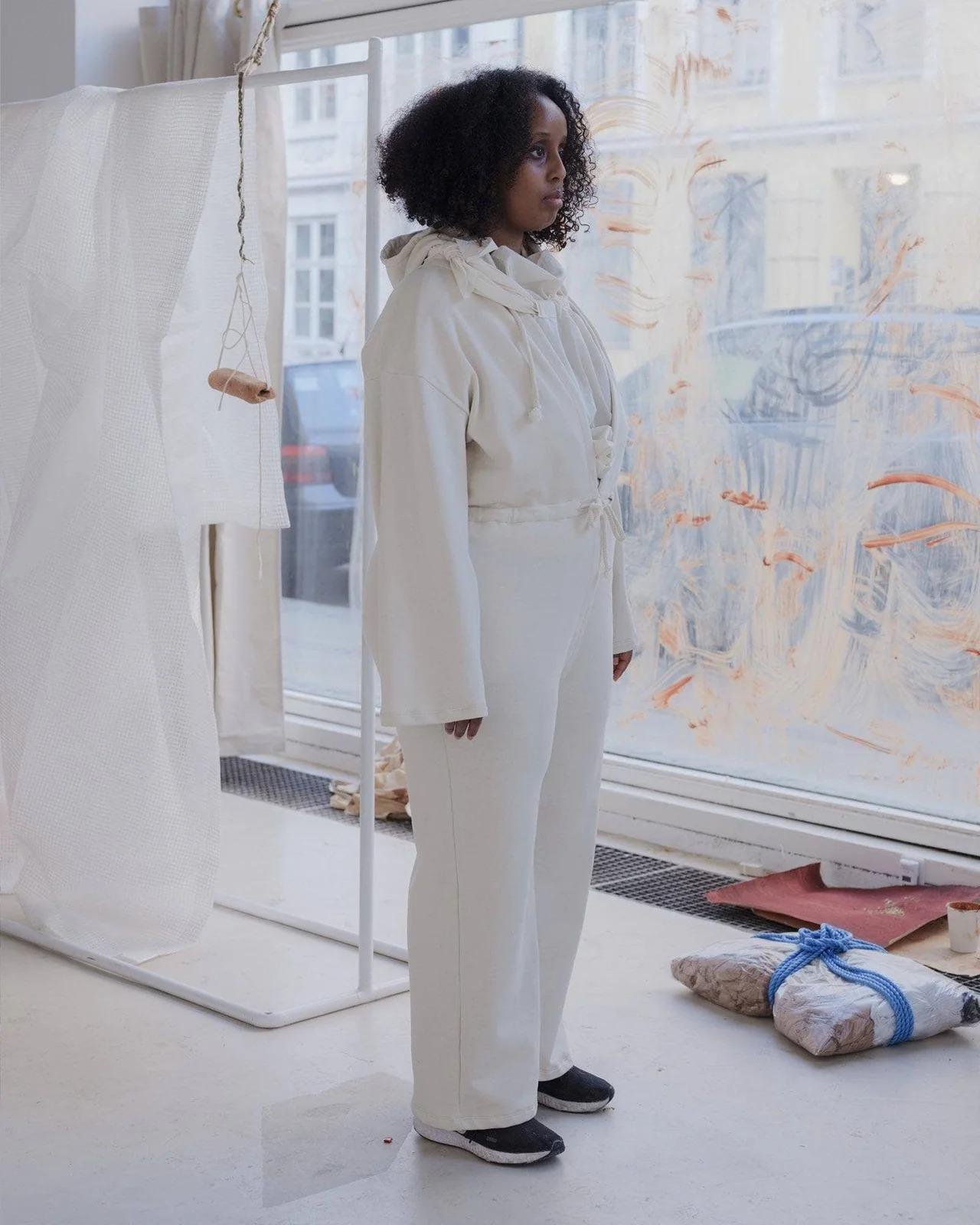 Model wearing the Baserange Ordu Jumpsuit Off-White from the side.
