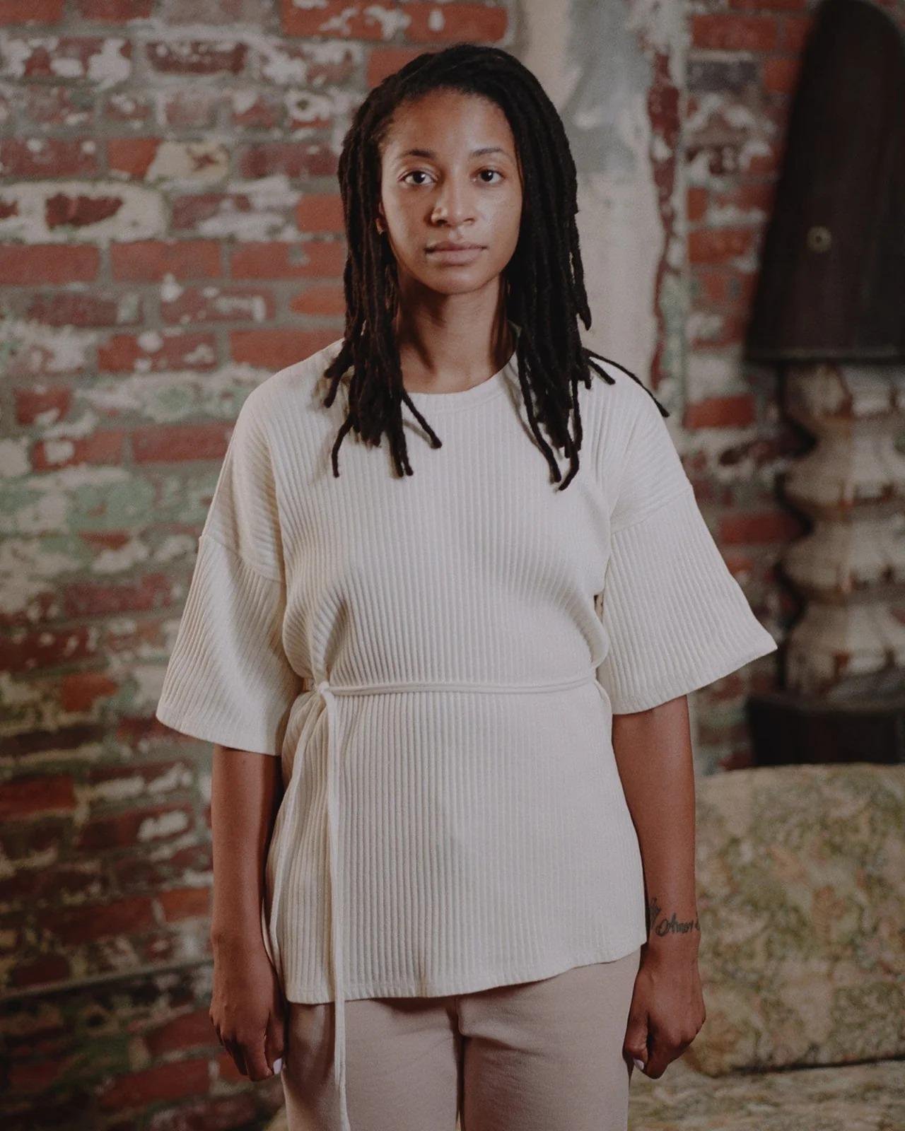 Model wearing the Baserange Shaw Tee in off-from the front.