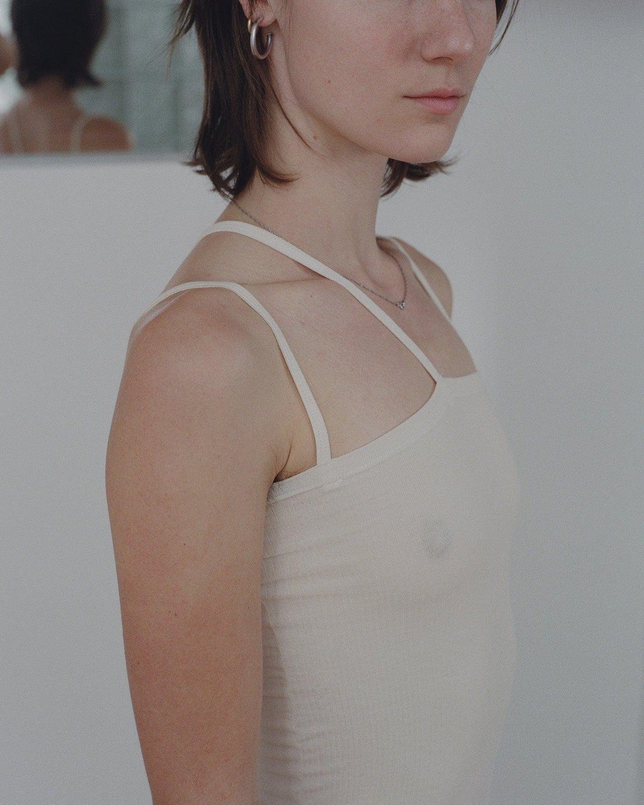 View of a person wearing the Baserange Nida Tank Top from the side.