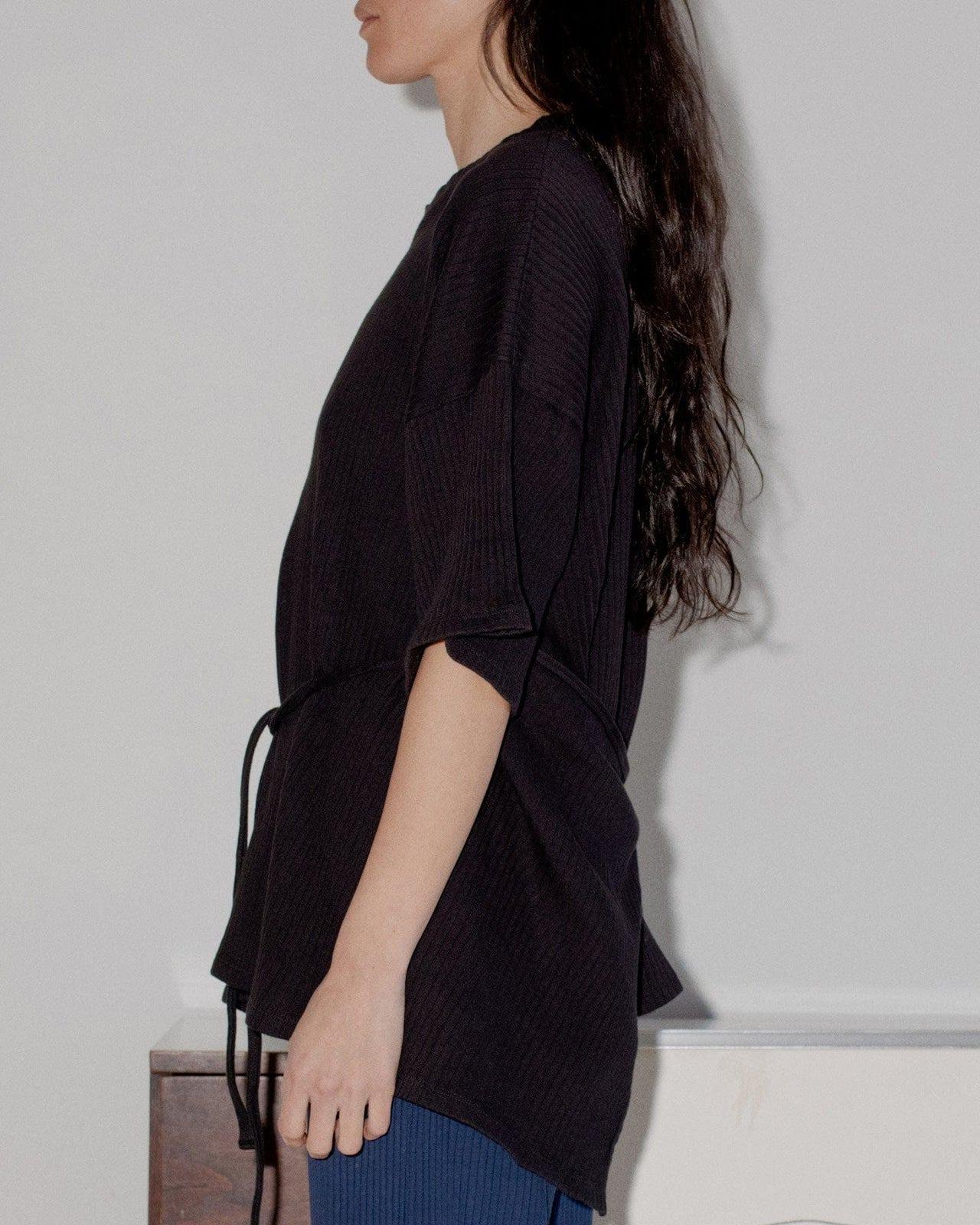 Person wearing the Baserange Shaw Tee from the side.