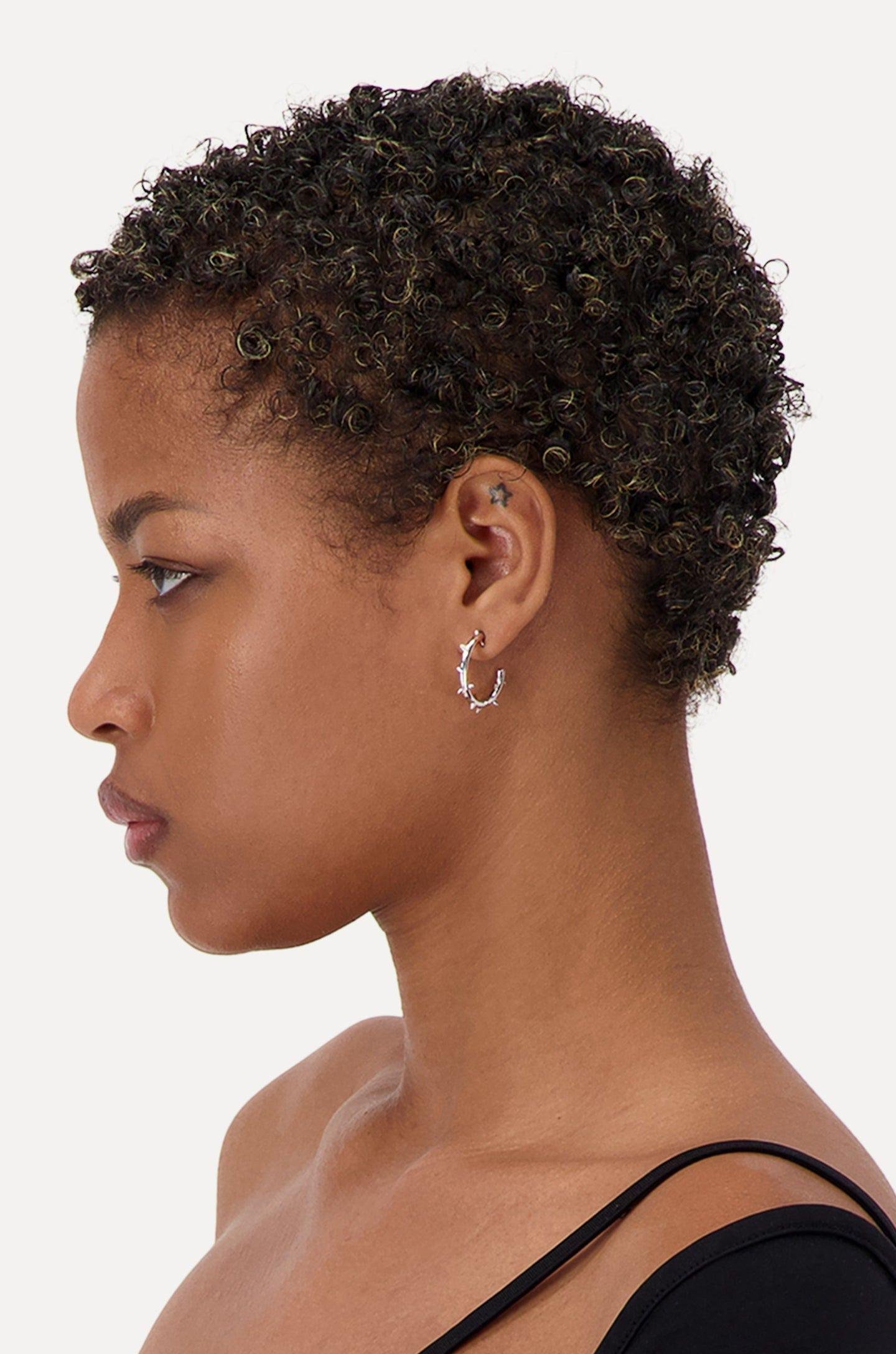 A person wearing the Justine Clenquet Hirschy Earrings.