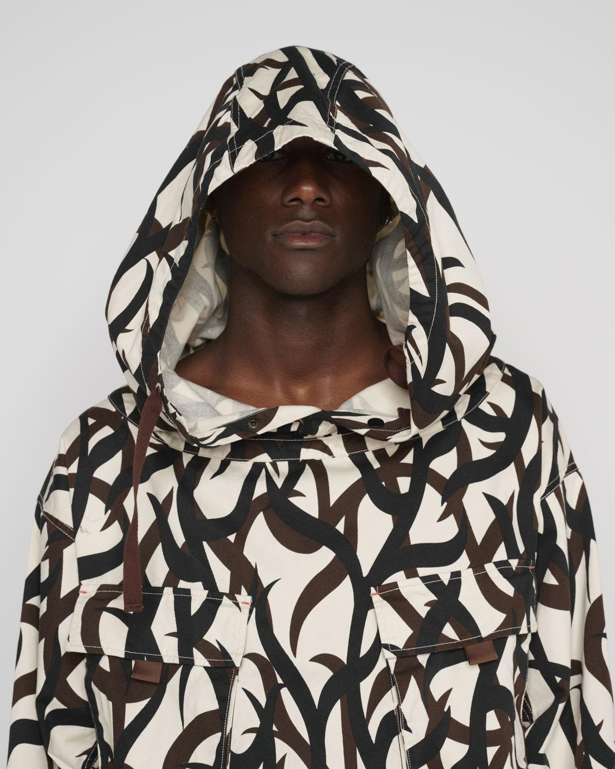 Model wearing the Brain Dead All Terrain Military Smock with the hood on