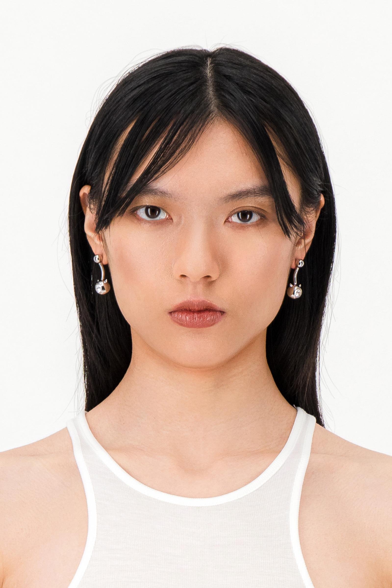 model wearing the Justine Clenquet Evil Earrings Crystal