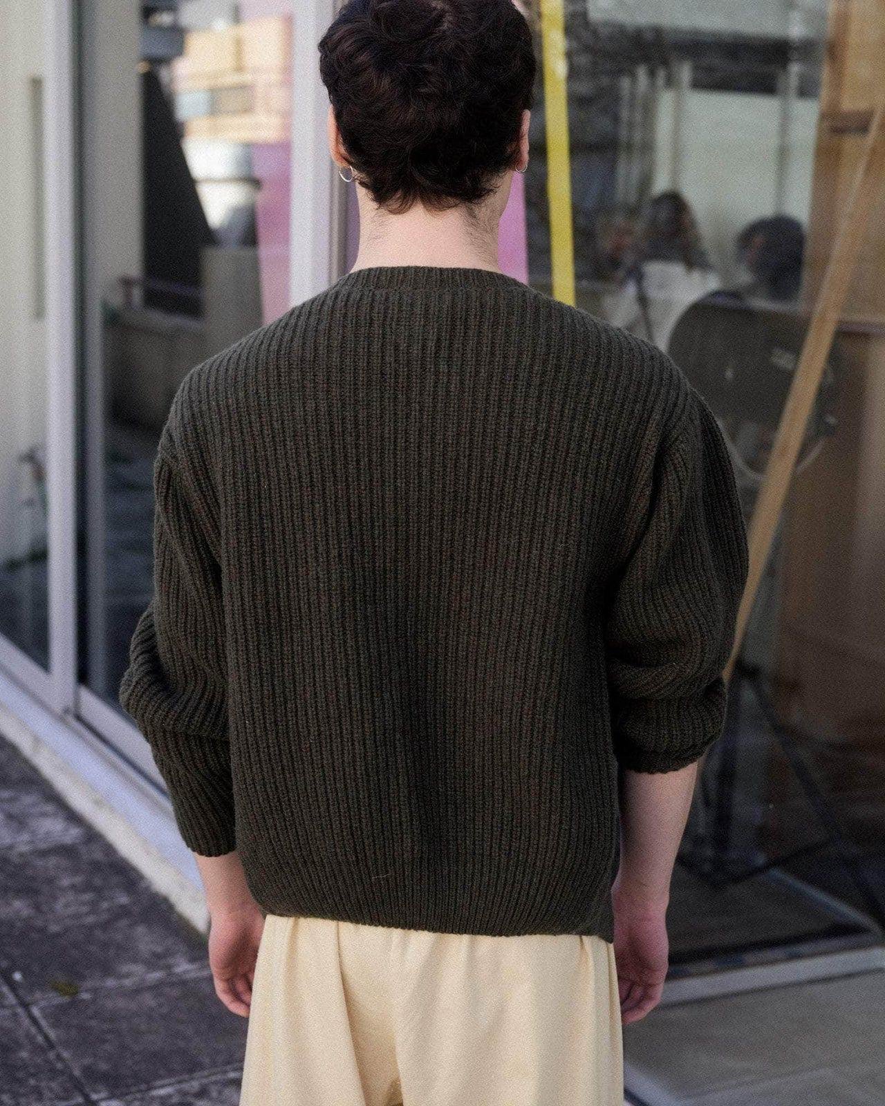 Person wearing the Baserange Mea Cardigan from the back.