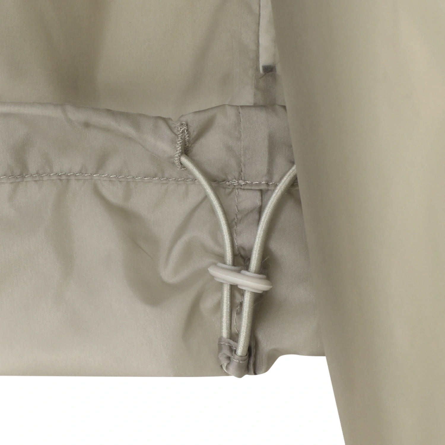 Amomento Sheer Hoodie Anorak Beige hem detail in a white background